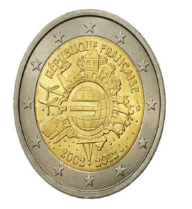 Lors d'une brocante, j'ai découvert une pièce française de 2 euros de 2012, commémorant les 10 ans de l'euro, en parfait état. Son design commémoratif captivait. À côté, une caméra vintage immortalisait des souvenirs, une radio ancienne diffusait des récits économiques, et un livre ancien sur l'histoire monétaire européenne enrichissait cette découverte historique et culturelle.